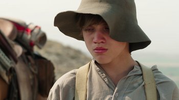 Movie still from “Catch the Bullet” (2021), directed by Michael Feifer – A young man wearing a hat and a backpack; Close Up shot, Over the shoulder angle