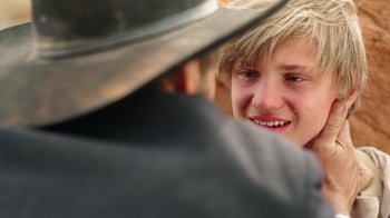 Movie still from “Catch the Bullet” (2021), directed by Michael Feifer – A young man smiling at another man with a hat on; Close Up shot, Over the shoulder angle