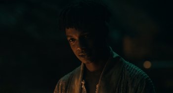 A young man is standing in the dark