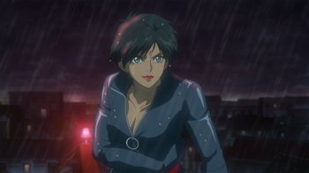A woman in a black and gray outfit standing in the rain