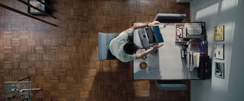Movie still from “The Secret Life of Walter Mitty” (2013), directed by Ben Stiller – A person sitting at a table with a laptop; Wide shot, Overhead angle