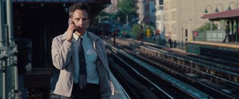 Movie still from “The Secret Life of Walter Mitty” (2013), directed by Ben Stiller – A man standing on the side of a train track talking on a cell phone; Medium shot, Over the shoulder angle
