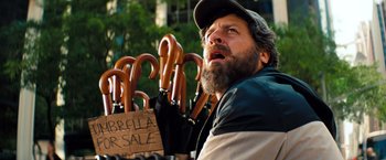 Movie still from “The Secret Life of Walter Mitty” (2013), directed by Ben Stiller – A bearded man holding a bunch of wooden umbrellas; Close Up shot, Low angle