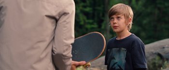 Movie still from “The Secret Life of Walter Mitty” (2013), directed by Ben Stiller – A young boy standing next to a person holding a skateboard; Medium shot, Over the shoulder angle