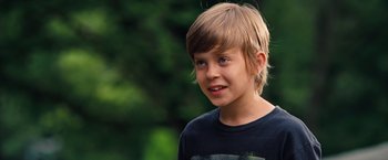Movie still from “The Secret Life of Walter Mitty” (2013), directed by Ben Stiller – A young boy is smiling for the camera outside; Close Up shot, Over the shoulder angle