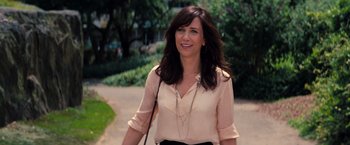 Movie still from “The Secret Life of Walter Mitty” (2013), directed by Ben Stiller – A woman in a beige shirt and black skirt walking; Medium shot, Over the shoulder angle