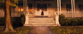 Movie still from “The Secret Life of Walter Mitty” (2013), directed by Ben Stiller – A woman sitting on a porch swing on the steps; Extreme Wide shot, Low angle