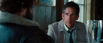 Movie still from “The Secret Life of Walter Mitty” (2013), directed by Ben Stiller – A man wearing a suit and tie sitting in front of another man; Close Up shot, Over the shoulder angle