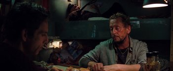 Movie still from “The Secret Life of Walter Mitty” (2013), directed by Ben Stiller – A man sitting at a table with a guitar in front of him; Medium shot, High angle