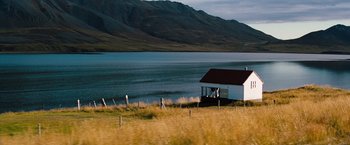 Movie still from “The Secret Life of Walter Mitty” (2013), directed by Ben Stiller – A small white house sitting next to a body of water; Extreme Wide shot, High angle