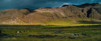 Movie still from “The Secret Life of Walter Mitty” (2013), directed by Ben Stiller – A large grassy field with a mountain in the background; Extreme Wide shot, High angle