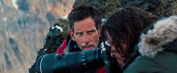 Movie still from “The Secret Life of Walter Mitty” (2013), directed by Ben Stiller – A man looking through a camera lens while another man looks on; Close Up shot, Over the shoulder angle