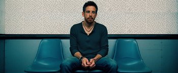 Movie still from “The Secret Life of Walter Mitty” (2013), directed by Ben Stiller – A man sitting on a bench with his hands in his pockets; Medium shot, Low angle