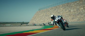 Movie still from “Centaur” (2022), directed by Daniel Calparsoro – A group of motorcyclists racing on a race track; Extreme Wide shot, High angle