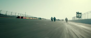 Movie still from “Centaur” (2022), directed by Daniel Calparsoro – A group of people riding motorcycles down a street; Extreme Wide shot, Low angle