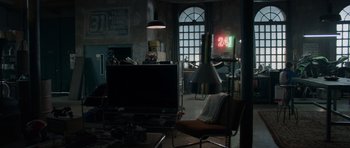 Movie still from “Centaur” (2022), directed by Daniel Calparsoro – A living room filled with furniture next to a window; Wide shot, High angle