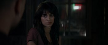 Movie still from “Centaur” (2022), directed by Daniel Calparsoro – A woman with long black hair wearing a brown shirt; Close Up shot, Over the shoulder angle