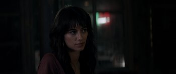 Movie still from “Centaur” (2022), directed by Daniel Calparsoro – A woman with long black hair looking at the camera; Close Up shot, Over the shoulder angle