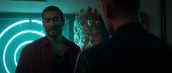 Movie still from “Centaur” (2022), directed by Daniel Calparsoro – Two men are talking in front of a mask; Close Up shot, Over the shoulder angle