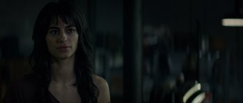 Movie still from “Centaur” (2022), directed by Daniel Calparsoro – A woman with long black hair standing in front of a window; Close Up shot, Over the shoulder angle