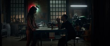 Movie still from “Centaur” (2022), directed by Daniel Calparsoro – A man and a woman sitting at a dining table; Wide shot, Low angle