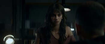 Movie still from “Centaur” (2022), directed by Daniel Calparsoro – A woman with long black hair is looking at the camera; Close Up shot, Over the shoulder angle