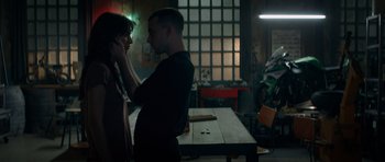 Movie still from “Centaur” (2022), directed by Daniel Calparsoro – A man and a woman standing next to each other in front of a table; Medium shot, Low angle