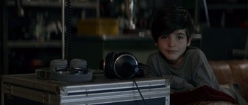 Movie still from “Centaur” (2022), directed by Daniel Calparsoro – A young boy sitting in front of a pair of headphones; Close Up shot, High angle