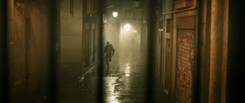 Movie still from “Centaur” (2022), directed by Daniel Calparsoro – A man walking down a street at night; Extreme Wide shot, Low angle