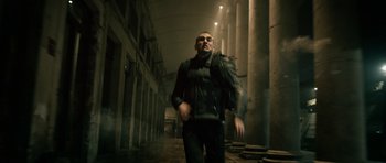 Movie still from “Centaur” (2022), directed by Daniel Calparsoro – A man walking down a street with a backpack; Wide shot, Low angle