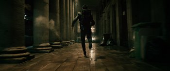 Movie still from “Centaur” (2022), directed by Daniel Calparsoro – A man running in the dark with a backpack on his back; Wide shot, Low angle