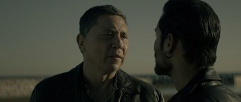 Movie still from “Centaur” (2022), directed by Daniel Calparsoro – A man in a leather jacket talking to another man in a leather jacket; Close Up shot, Over the shoulder angle