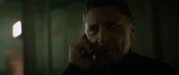 Movie still from “Centaur” (2022), directed by Daniel Calparsoro – An older man talking on a cell phone in the dark; Close Up shot, Low angle