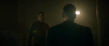 Movie still from “Centaur” (2022), directed by Daniel Calparsoro – Two men are standing in the dark in front of a mirror; Medium shot, Over the shoulder angle