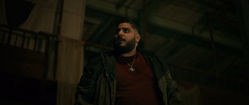 Movie still from “Centaur” (2022), directed by Daniel Calparsoro – A man with a beard wearing a brown shirt; Medium shot, Low angle