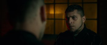 Movie still from “Centaur” (2022), directed by Daniel Calparsoro – A man looking at another man in a dark room; Close Up shot, Over the shoulder angle