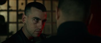 Movie still from “Centaur” (2022), directed by Daniel Calparsoro – A man looking at another man in a dark room; Close Up shot, Over the shoulder angle