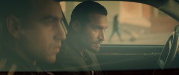 Movie still from “Centaur” (2022), directed by Daniel Calparsoro – A man sitting in the back seat of a car looking out of the window; Close Up shot, Over the shoulder angle