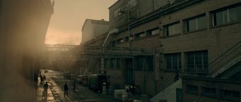 Movie still from “Centaur” (2022), directed by Daniel Calparsoro – An industrial building with a fire truck parked in front of it; Extreme Wide shot, Low angle