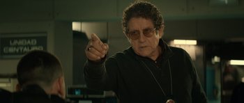 Movie still from “Centaur” (2022), directed by Daniel Calparsoro – An older man wearing sunglasses and a black jacket; Close Up shot, Over the shoulder angle