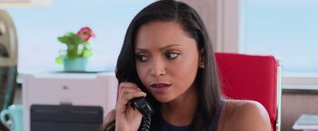 Movie still from “Central Intelligence” (2016), directed by Rawson Marshall Thurber – A woman talking on a phone while sitting at a desk; Close Up shot, Over the shoulder angle