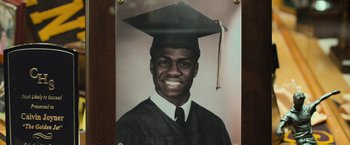Movie still from “Central Intelligence” (2016), directed by Rawson Marshall Thurber – A man in a graduation cap and gown smiling; Extreme Close Up shot, Overhead angle