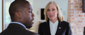 Movie still from “Central Intelligence” (2016), directed by Rawson Marshall Thurber – A woman wearing a suit and tie talking to a man in a black suit; Close Up shot, Over the shoulder angle