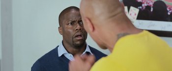 Movie still from “Central Intelligence” (2016), directed by Rawson Marshall Thurber – A man looking into a mirror while another man holds his hand up to his face; Close Up shot, Over the shoulder angle