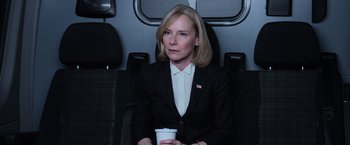 Movie still from “Central Intelligence” (2016), directed by Rawson Marshall Thurber – A woman sitting on a seat holding a cup of coffee; Medium shot, Low angle