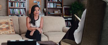 Movie still from “Central Intelligence” (2016), directed by Rawson Marshall Thurber – A woman sitting on a chair in a living room; Medium shot, Over the shoulder angle