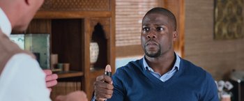 Movie still from “Central Intelligence” (2016), directed by Rawson Marshall Thurber – A man holding a remote control in his hand; Close Up shot, Over the shoulder angle