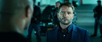 Movie still from “Central Intelligence” (2016), directed by Rawson Marshall Thurber – A person wearing a suit and tie; Close Up shot, Over the shoulder angle