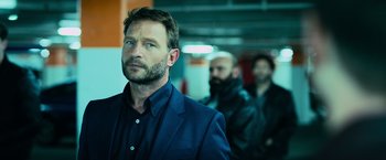 Movie still from “Central Intelligence” (2016), directed by Rawson Marshall Thurber – A man in a blue suit standing in front of another man in a black jacket; Close Up shot, Over the shoulder angle