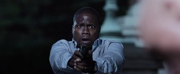 Movie still from “Central Intelligence” (2016), directed by Rawson Marshall Thurber – A man holding a gun in his hand; Close Up shot, Over the shoulder angle